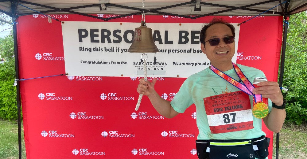 Eric Li rings the PB bell at the 2022 Saskatchewan Marathon after running 42.2km in 4:00:29.